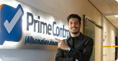 Profissional da Prime Control apontando para o logotipo Prime Control na parede da recepção