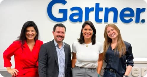Quatro profissionais posando diante do logotipo Gartner