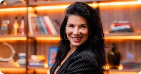Elaine Póvoas, Head de Marketing e Alianças, diante de uma estante iluminada